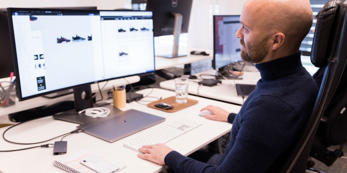 En man som sitter och jobbar vid sin dator på ett kontor